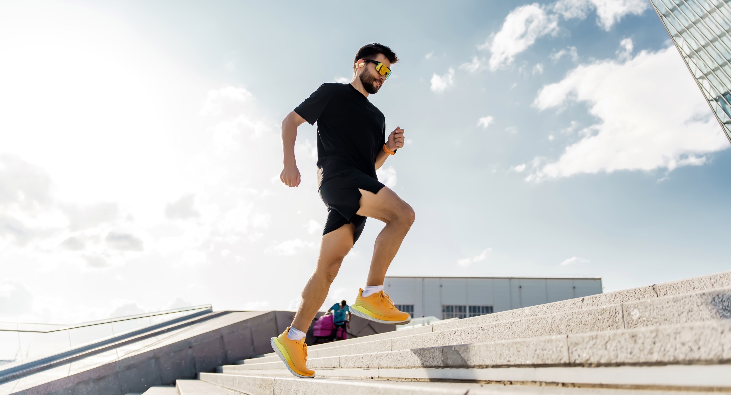 Man running up outdoor steps and enjoying music in FINGERS OWaveS bluetooth tws