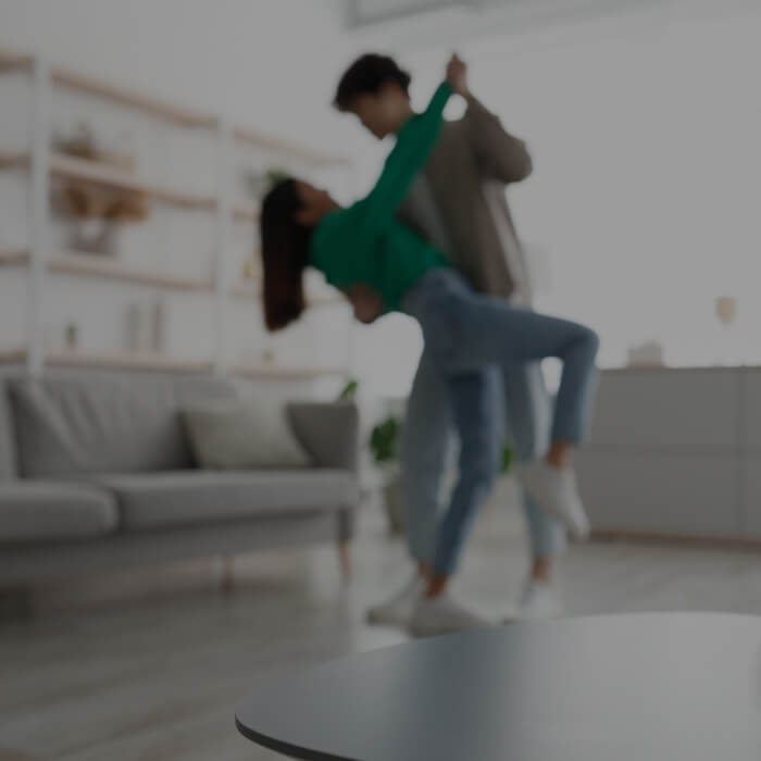 A couple is seen dancing in their home