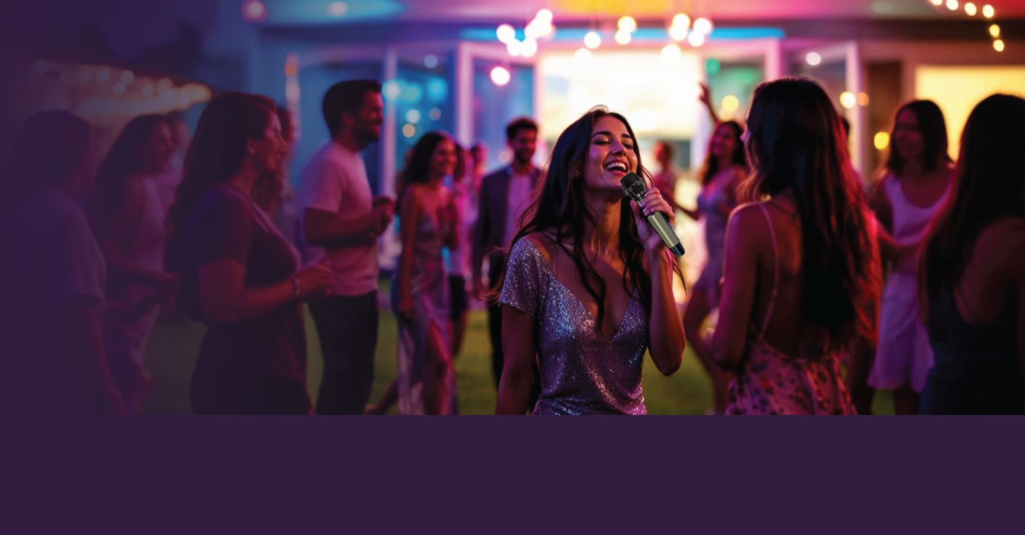 A woman joyfully sings karaoke at a vibrant outdoor night party with friends